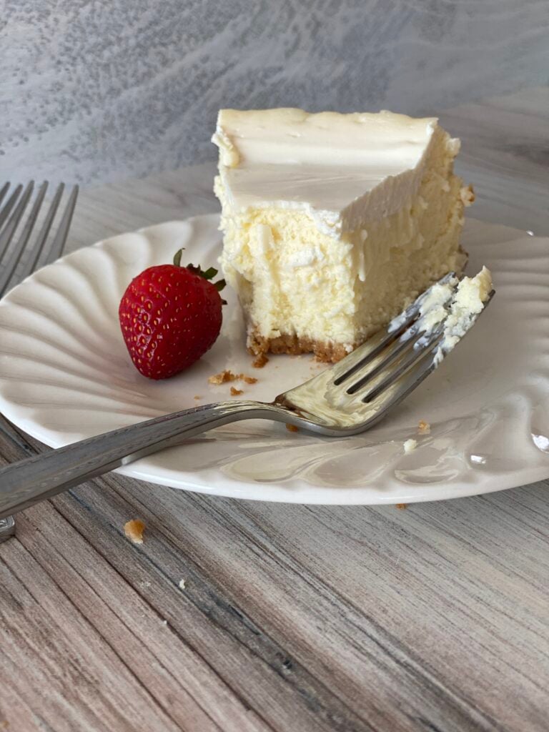 a bite from a creamy cheesecake slice