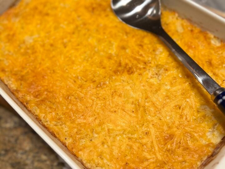 A easy cheesy hashbrown casserole baked in a 13x9 white dish.